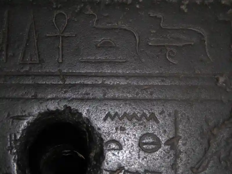 Ankh, triangle, half-moon, zig-zag, circle with line in the center symbols on a stone